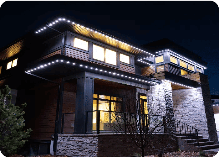 Modern home exterior illuminated by LED lights at night, showcasing architectural design.