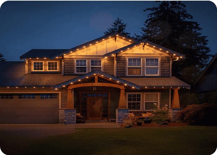 Cozy home adorned with warm LED string lights at dusk, showcasing beautiful architecture.
