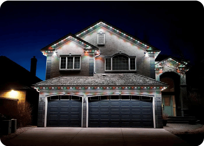 Home decorated with colorful Christmas lights at night, showcasing a festive holiday spirit.
