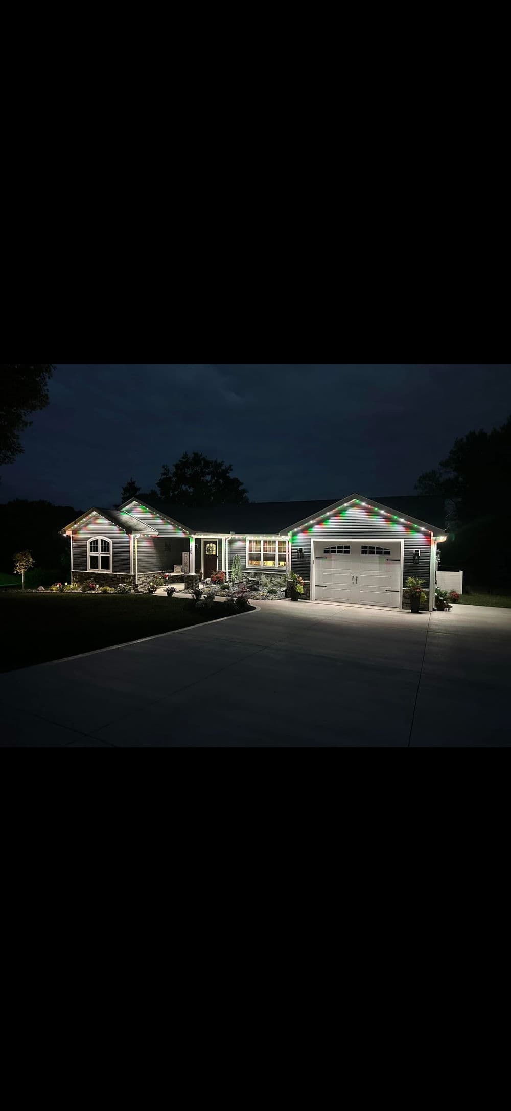 Charming house decorated with colorful lights at night, showcasing a welcoming entrance.