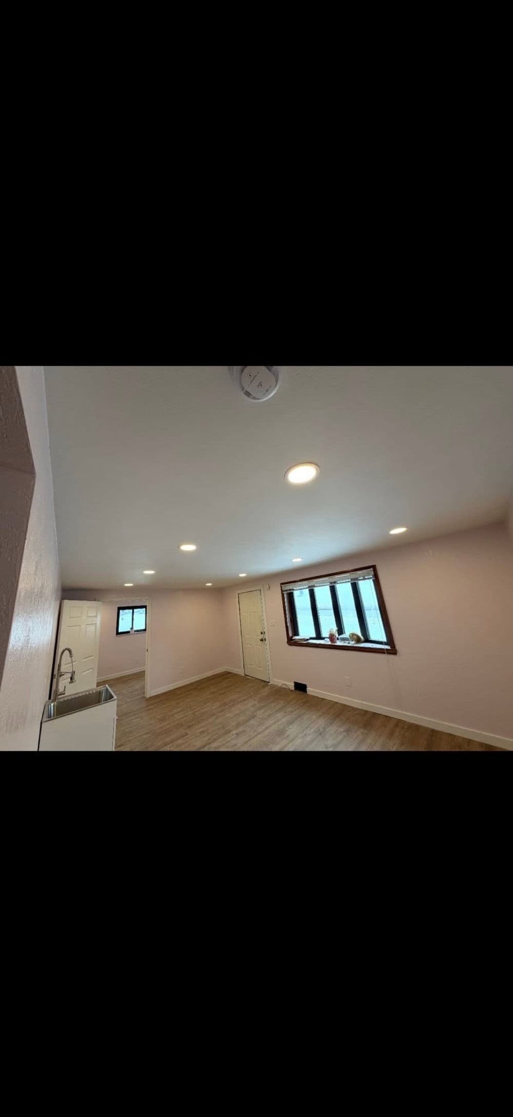 Spacious, well-lit interior room with pink walls and large windows showcasing natural light.